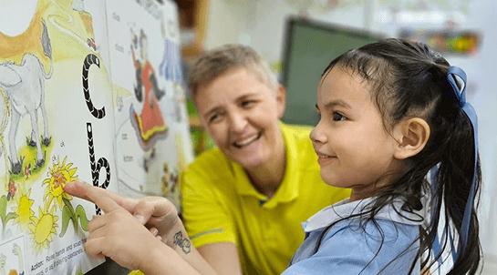 ครูทำงานกับนักเรียนเกี่ยวกับการอ่าน